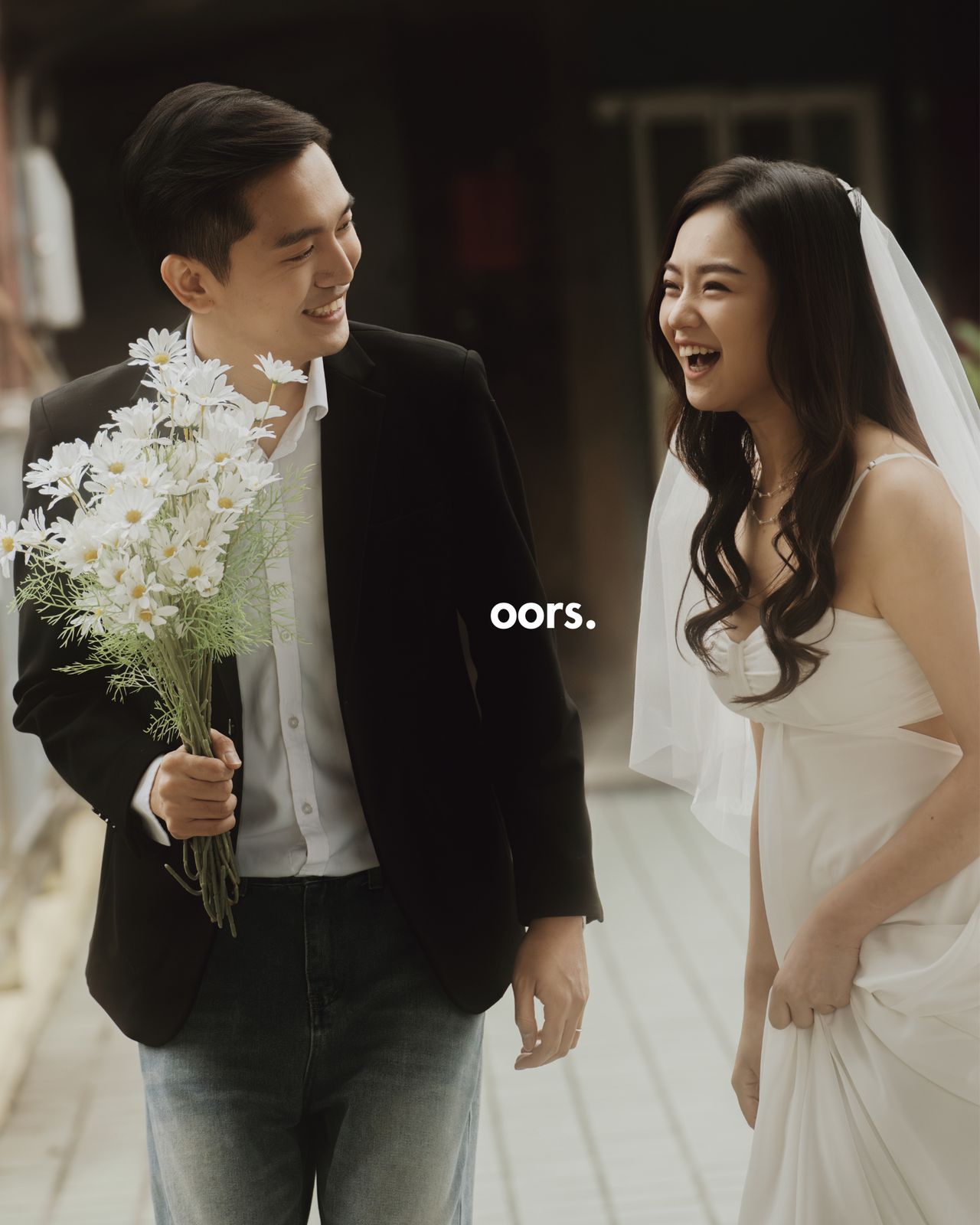 The groom and bride laughing on a wooden walkway