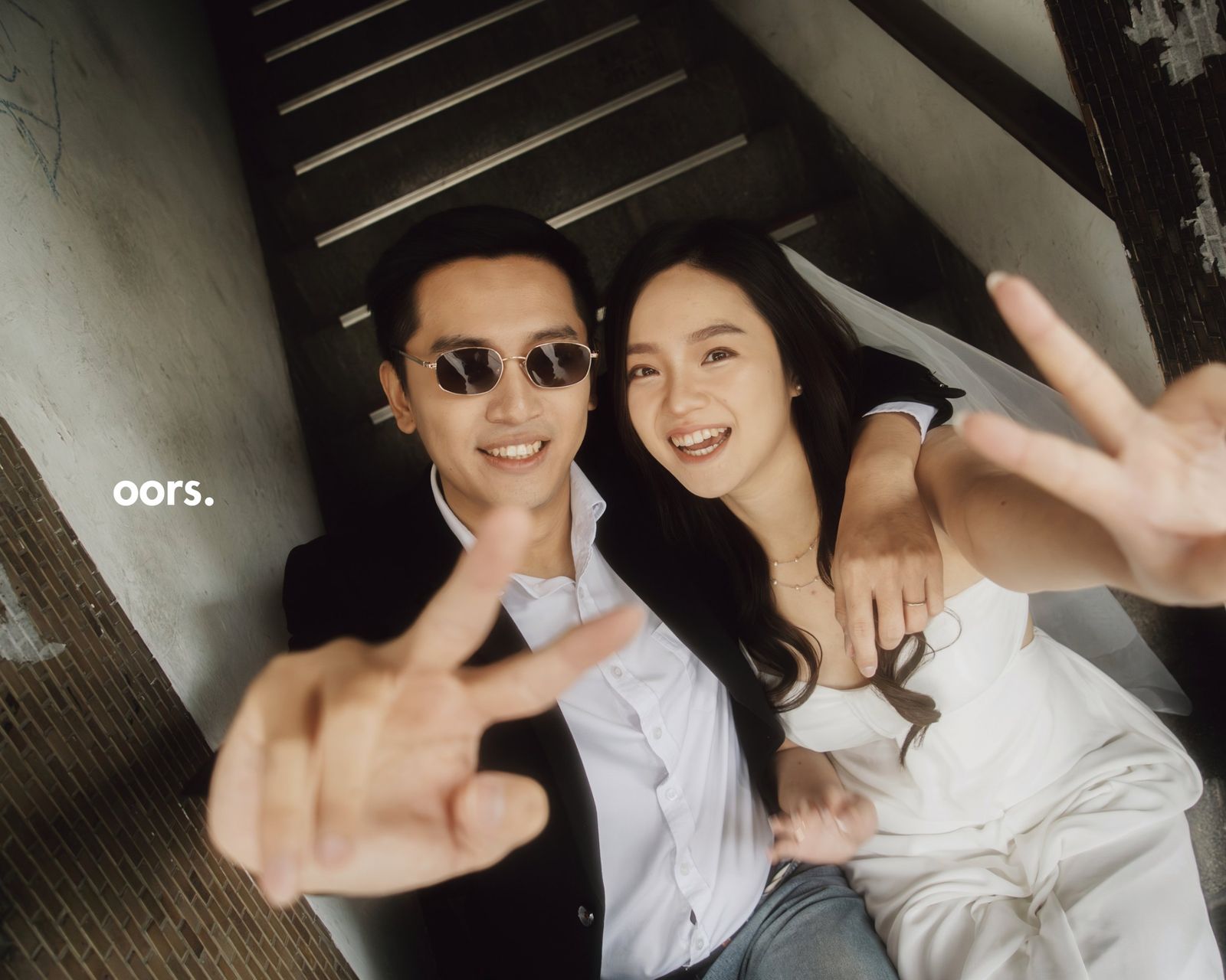 The couple on a staircase, flashing peace signs
