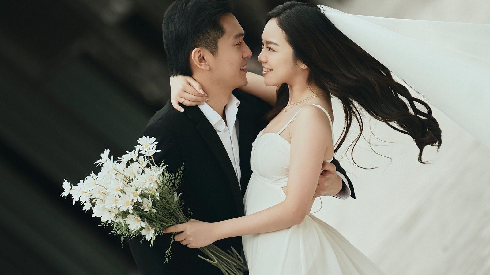 The couple dancing close, her veil trailing