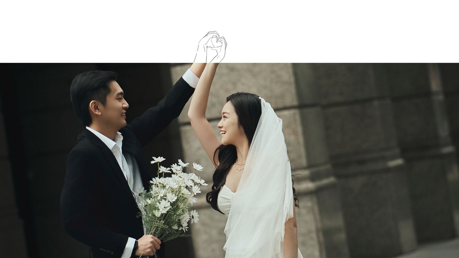 Raising their joined hands to draw a heart