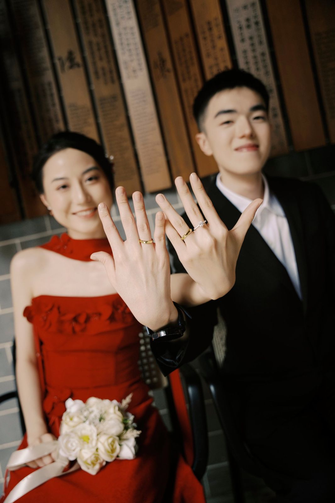 The couple holding up their hands to show their rings