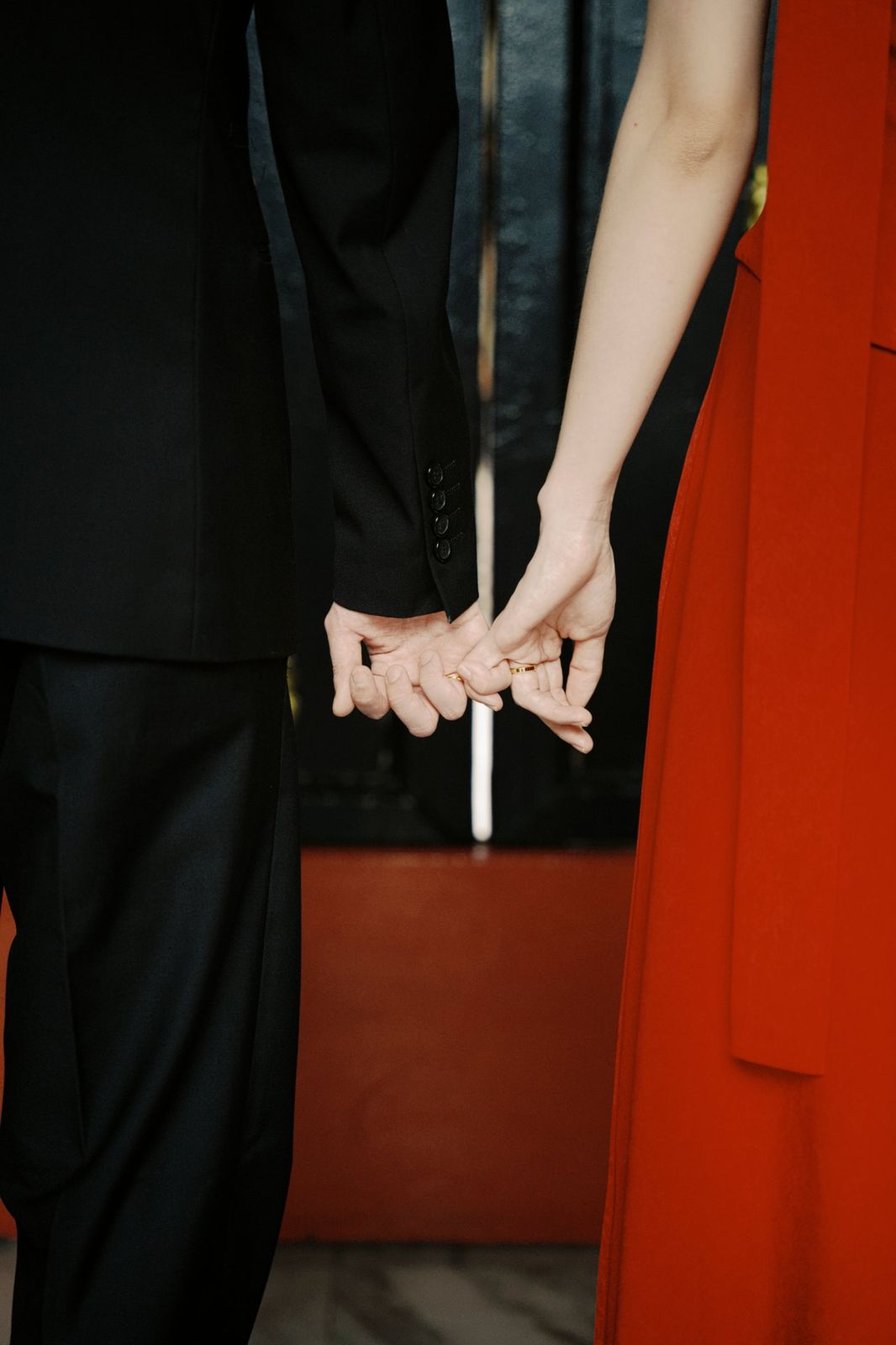 The couple's hands linked by their little fingers