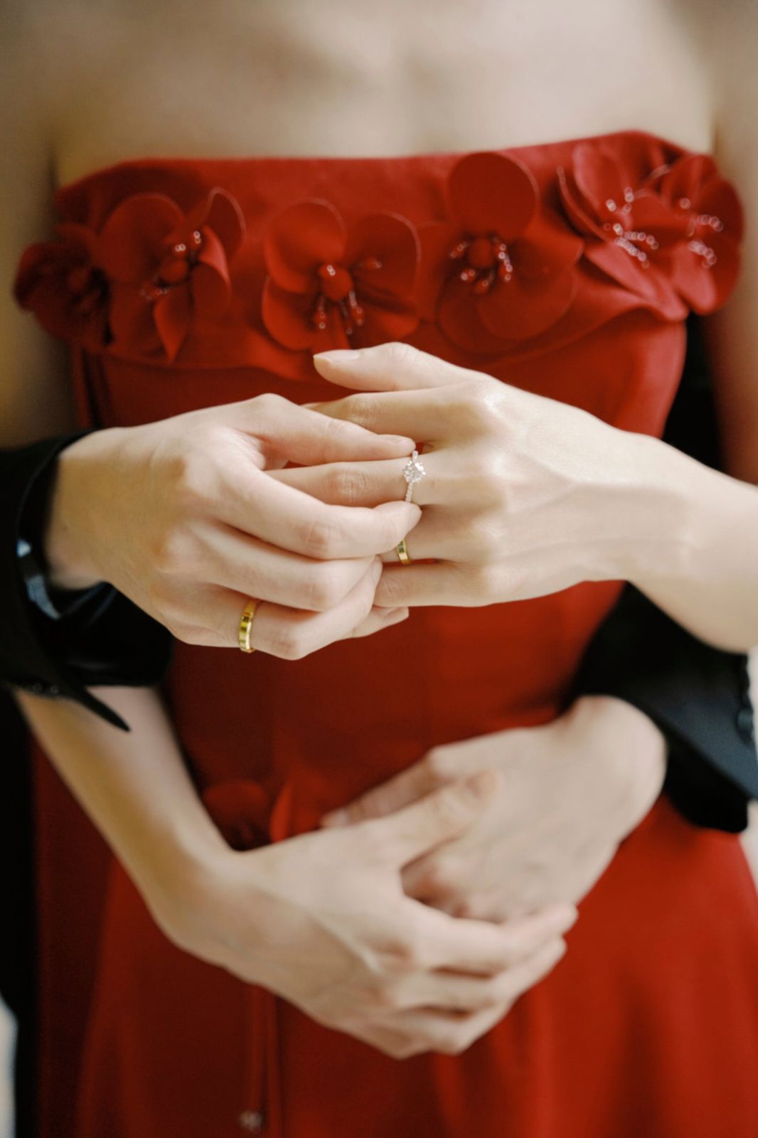 Hands and rings against the red dress