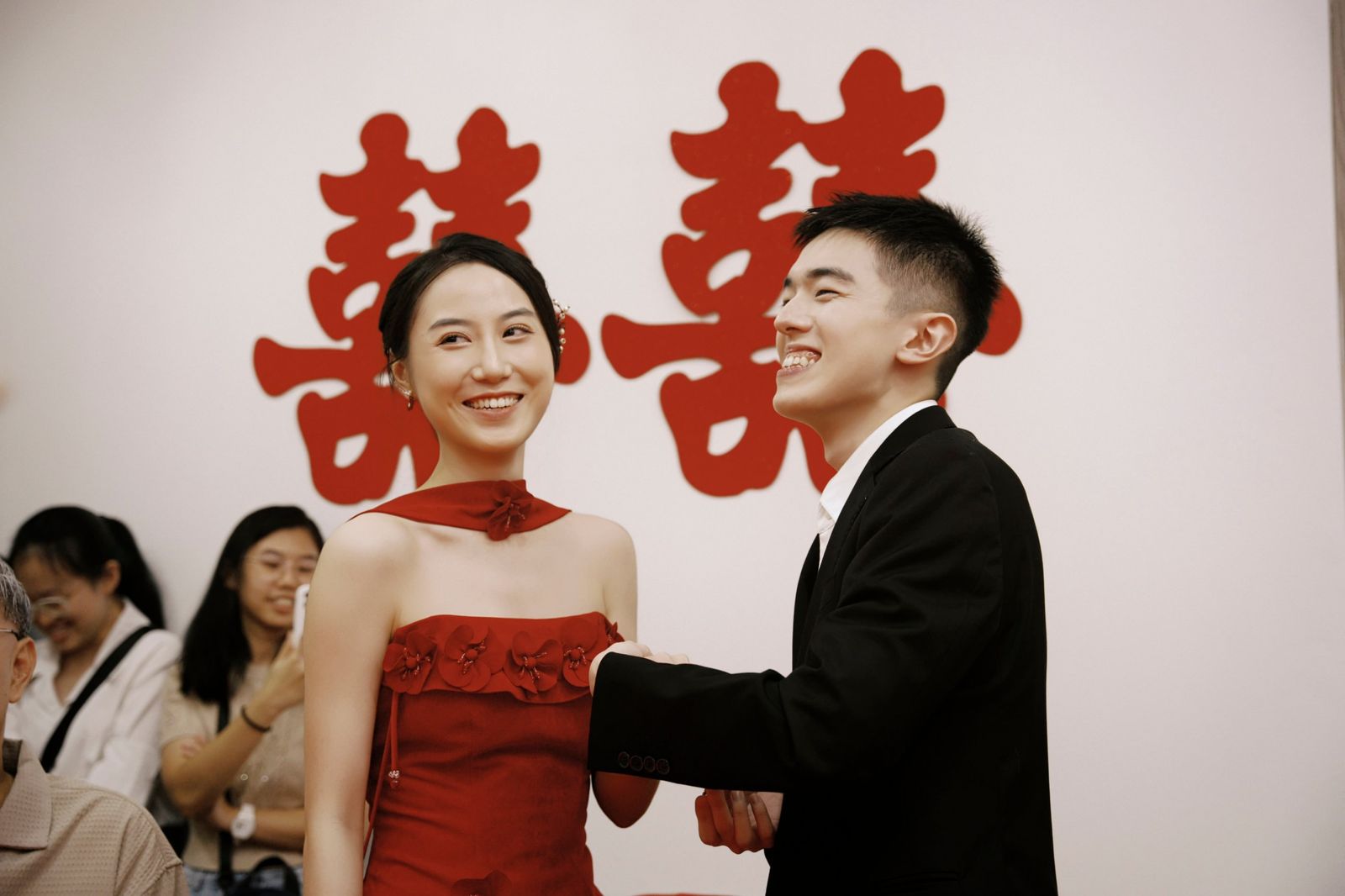 The couple laughing in front of the double-happiness characters