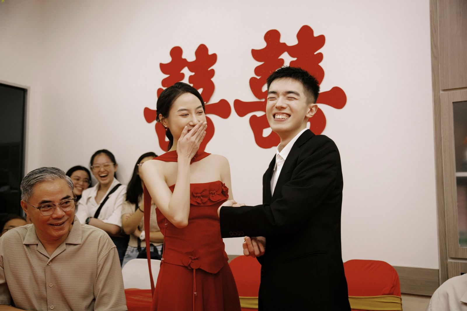 The bride covering her smile, the groom laughing out loud