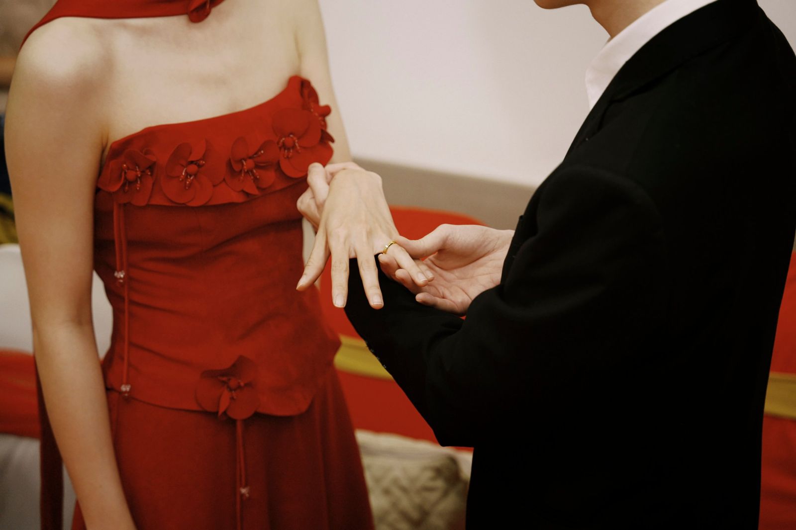 The groom placing the ring on the bride's finger