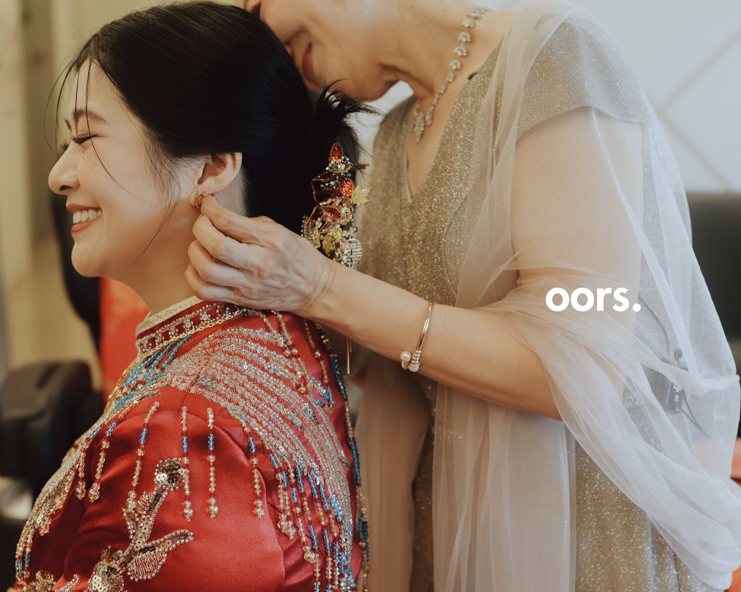 A mother putting an earring on the bride