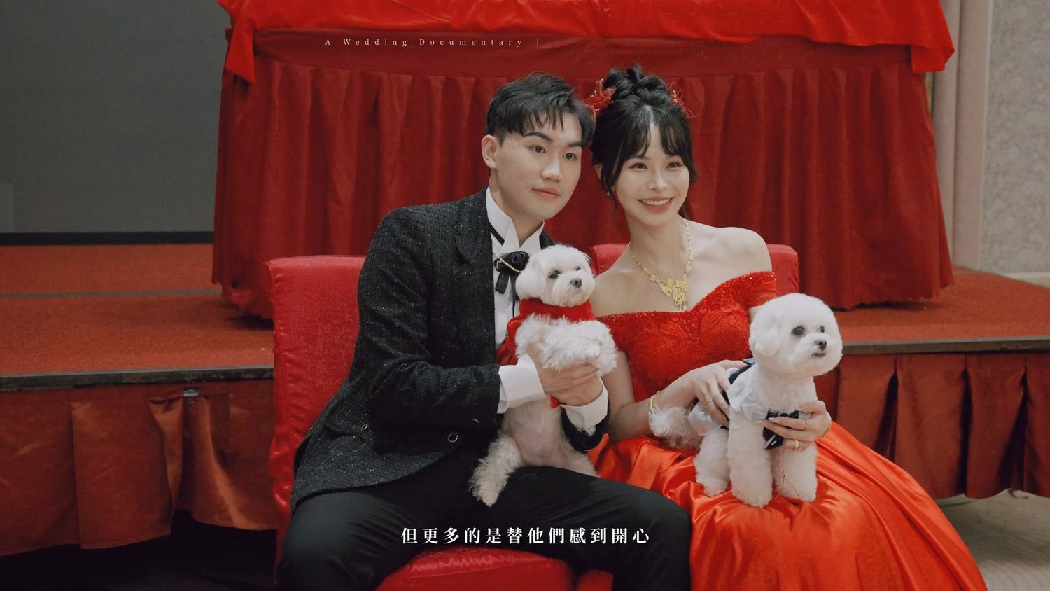 The couple holding two small white dogs