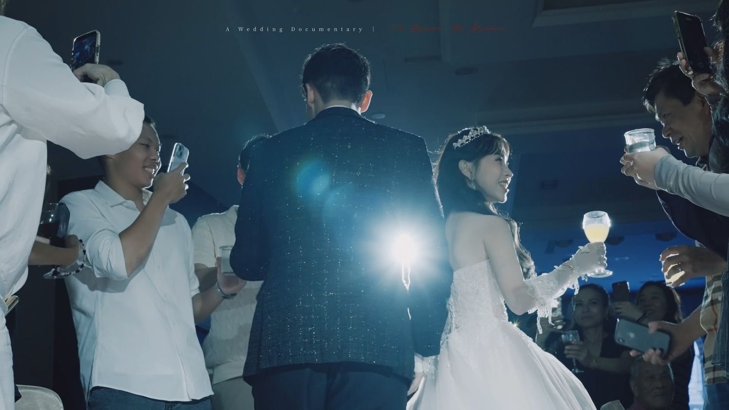 Guests raising glasses as the couple walks in