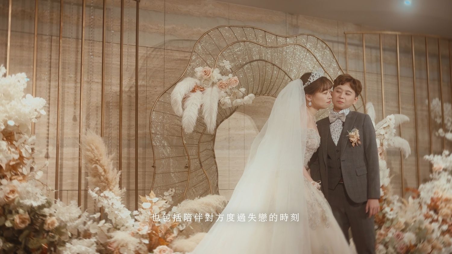 The couple before a gold leaf-shaped backdrop