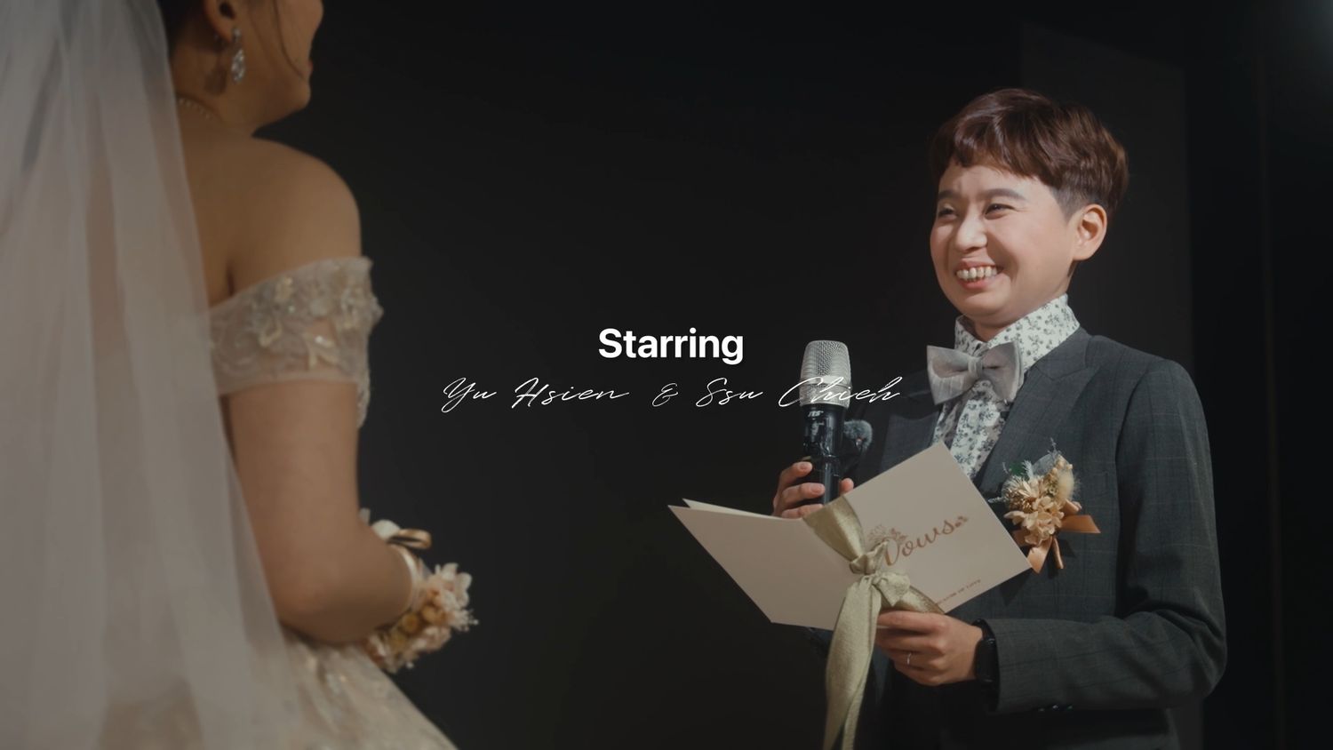 The groom smiling as he reads his vows