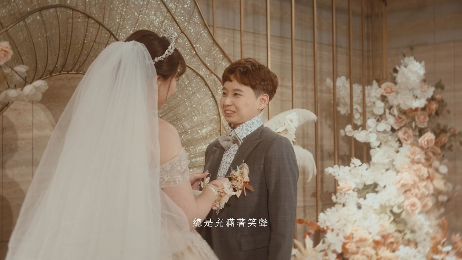 The couple facing each other, her veil flowing