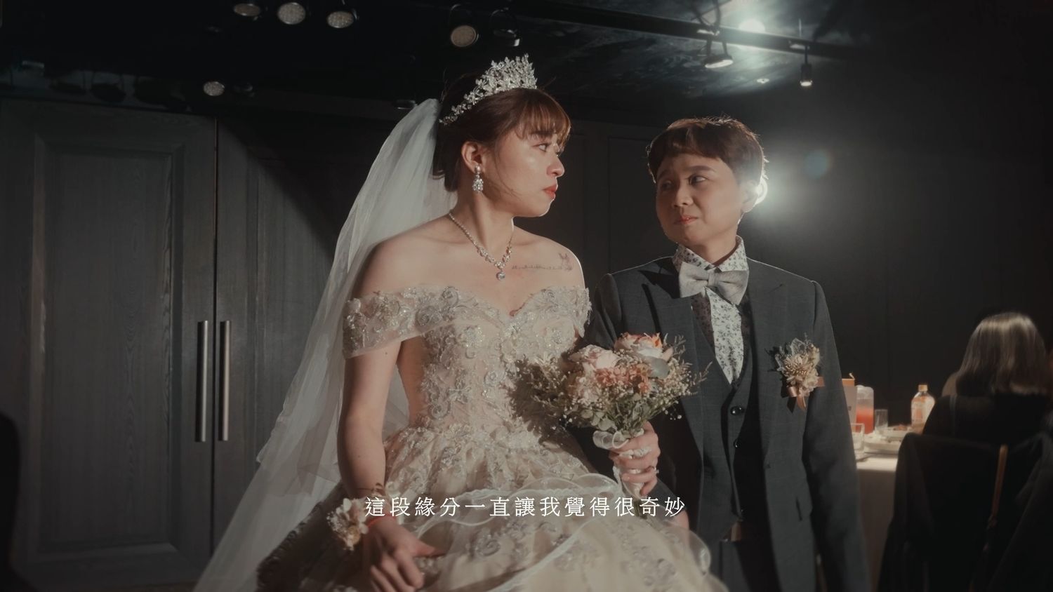 The couple walking together, glancing at one another