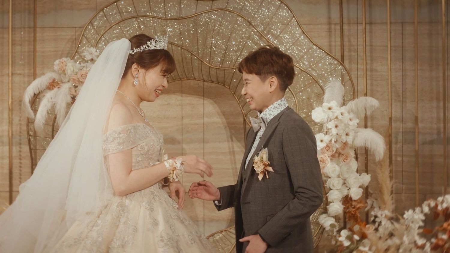 The couple laughing in front of the backdrop