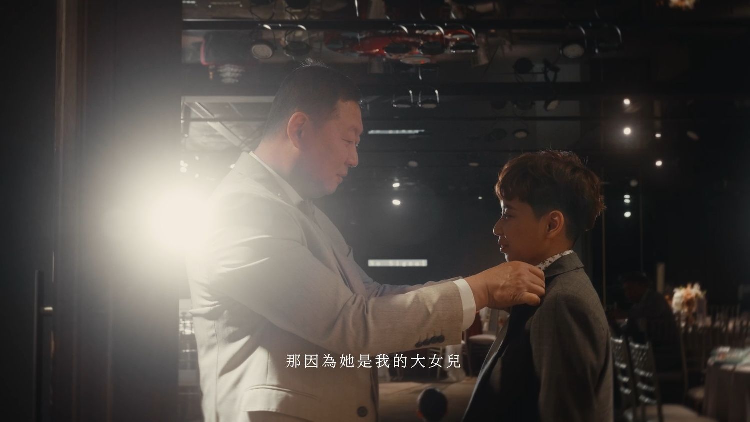 A father straightening the groom's tie