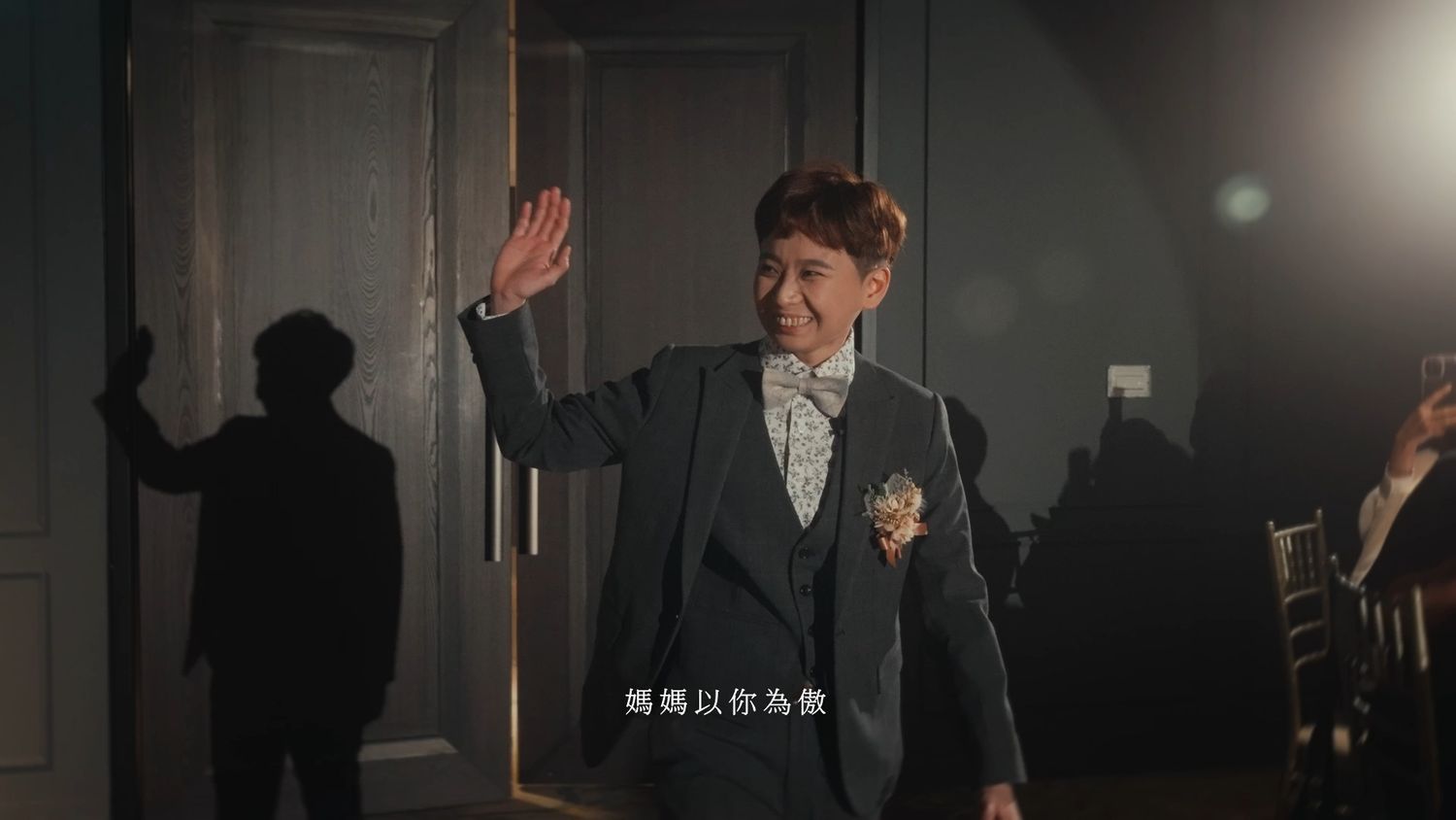 The groom waving as he walks in