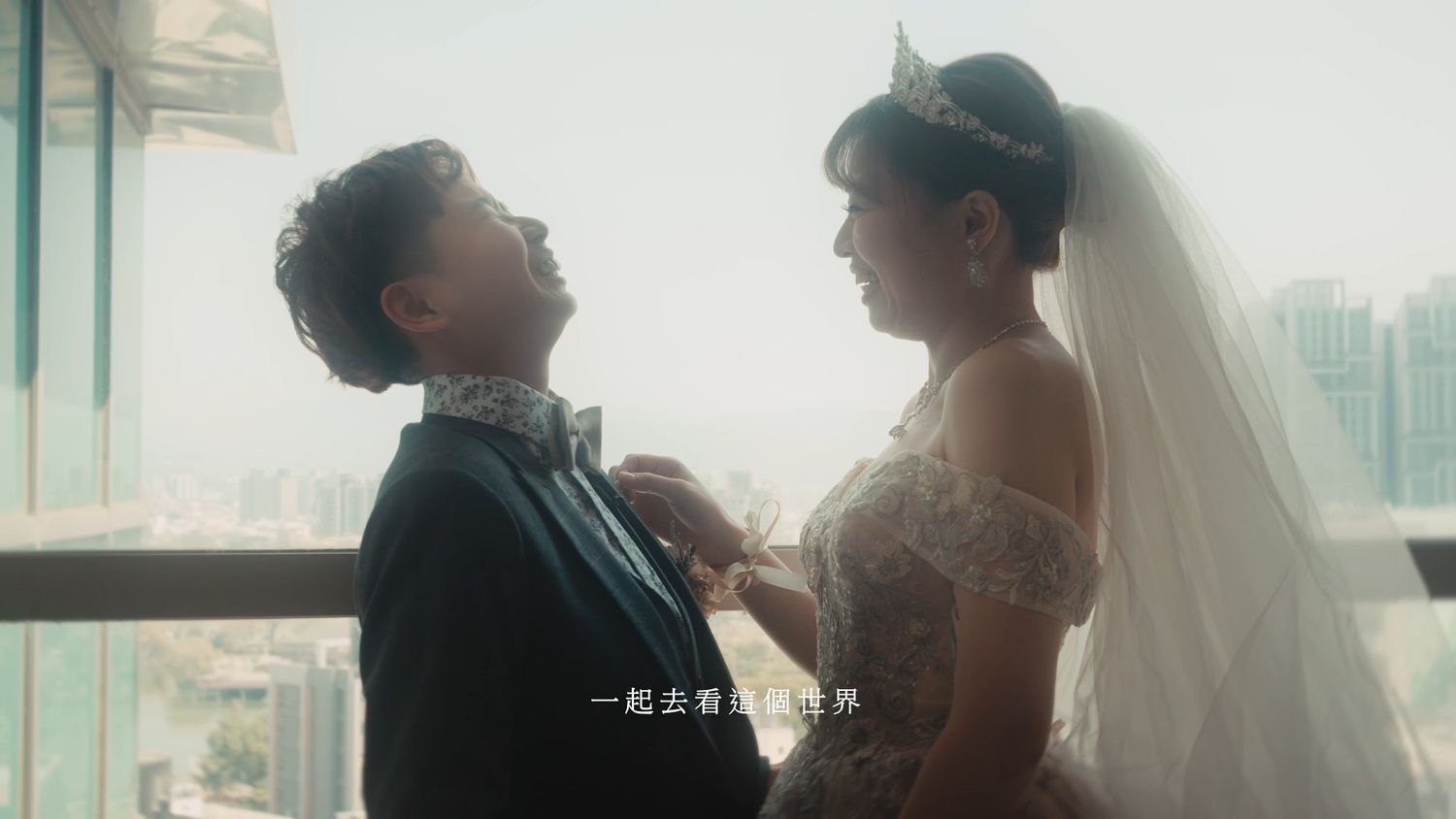 The groom laughing as the bride adjusts his collar